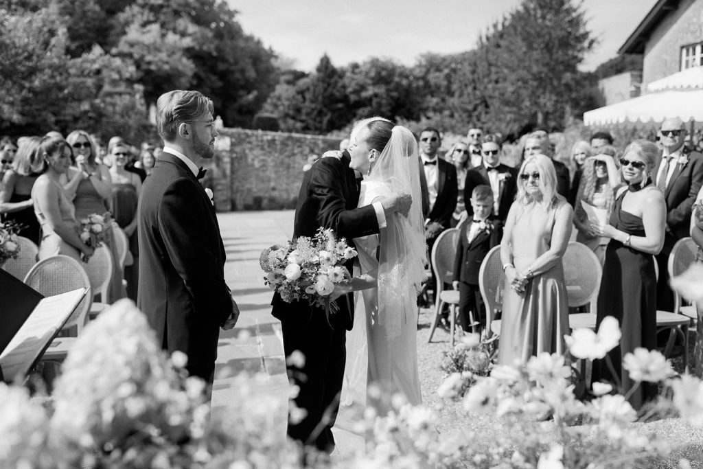 Bride hugging family member during outdoor wedding ceremony at Ripple Court Estate in Kent