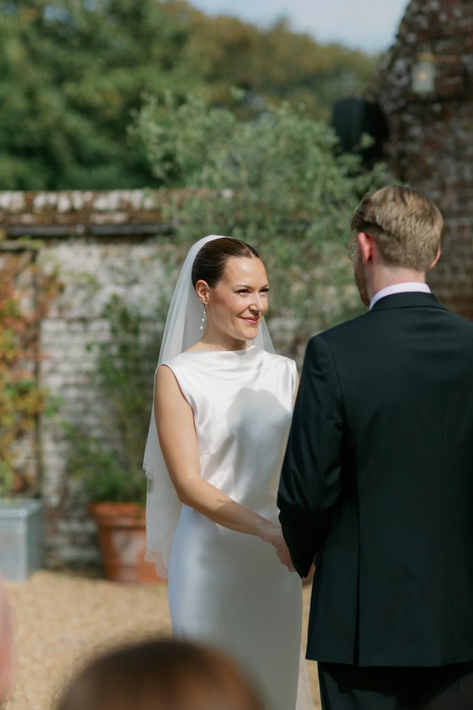 Bride and groom holding hands during their outdoor wedding ceremony at Ripple Court Estate in Kent