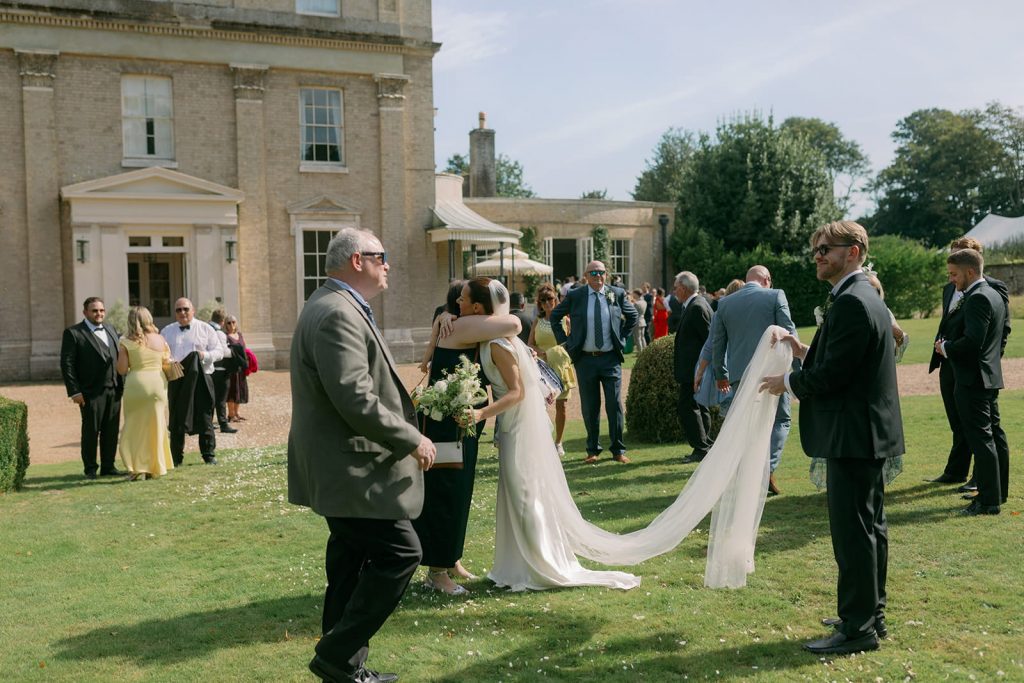 Bride hugging a guest during wedding drinks reception
