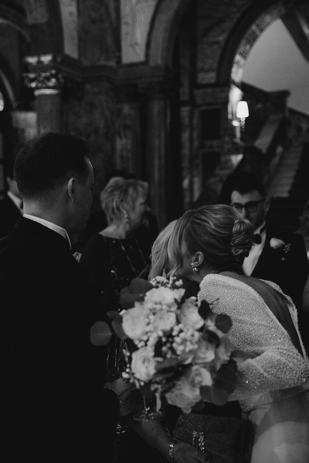 Bride holding bouquet and greeting guests with soft textured updo and natural bridal makeup at Kimpton Fitzroy London