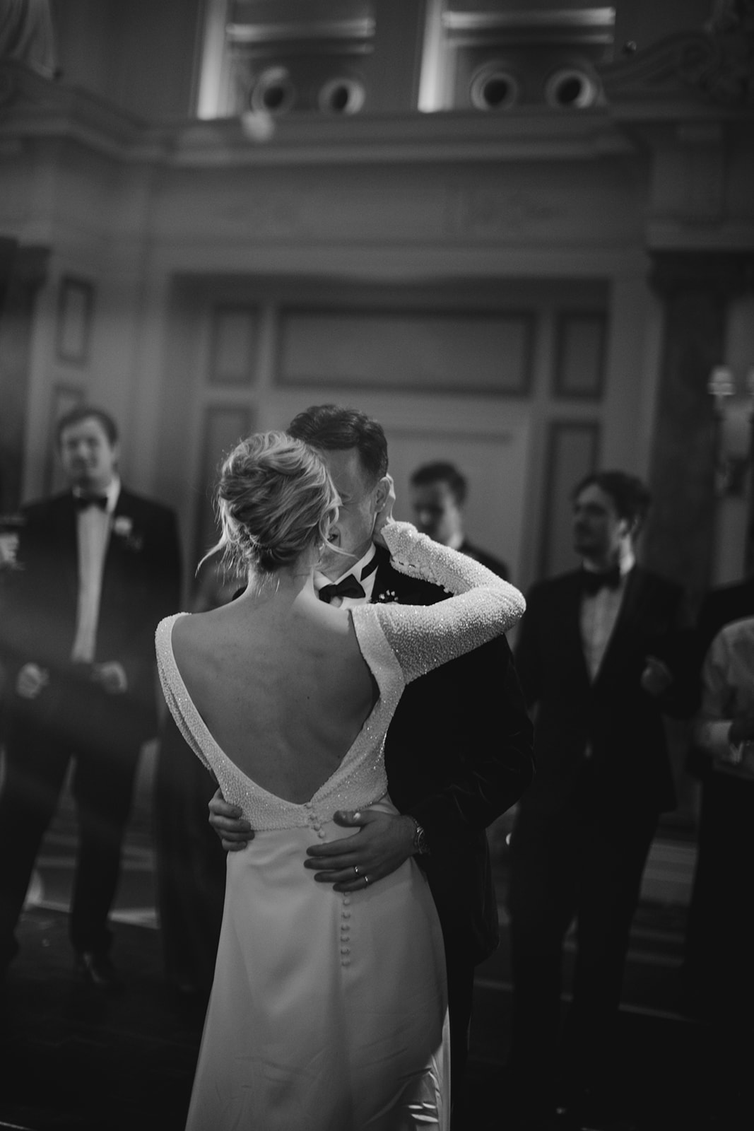 Bride and groom sharing first dance with bride wearing relaxed updo and luminous natural makeup in London ballroom