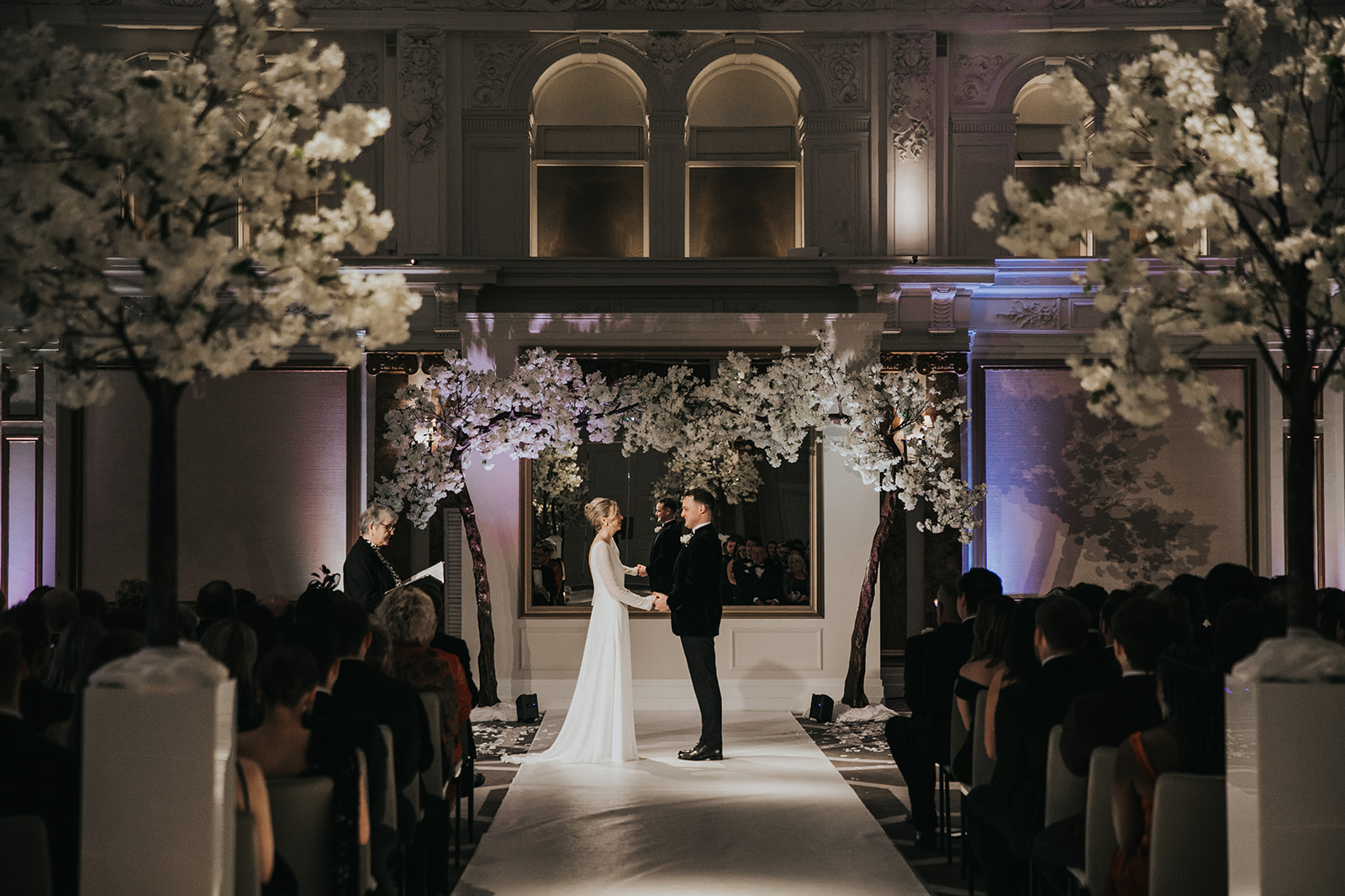 Wide ceremony view with floral trees and aisle at Kimpton Fitzroy London wedding venue