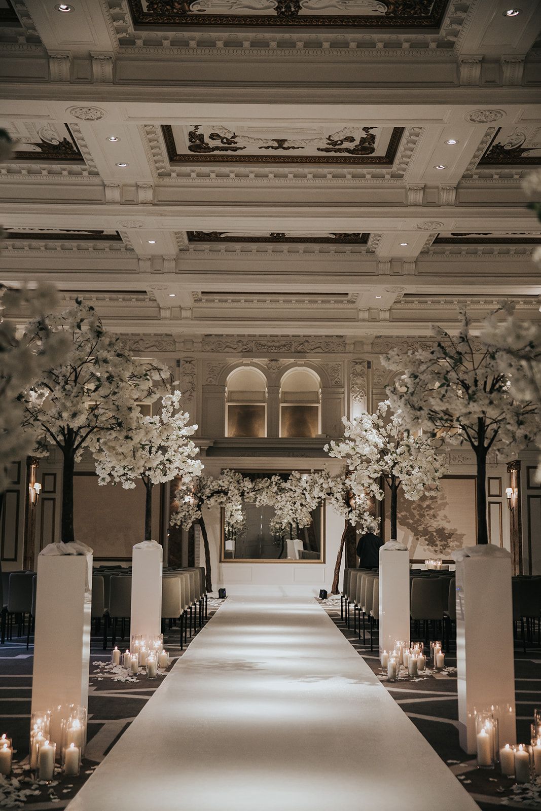 Empty ceremony setup with candles lining aisle and floral trees at Kimpton Fitzroy London
